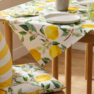 Mediterrane Küchendekoration mit Zitronen-Tischdecke, passenden Sitzkissen, Ofenhandschuhen und Gläsern für ein sommerliches Dolce-Vita-Ambiente.